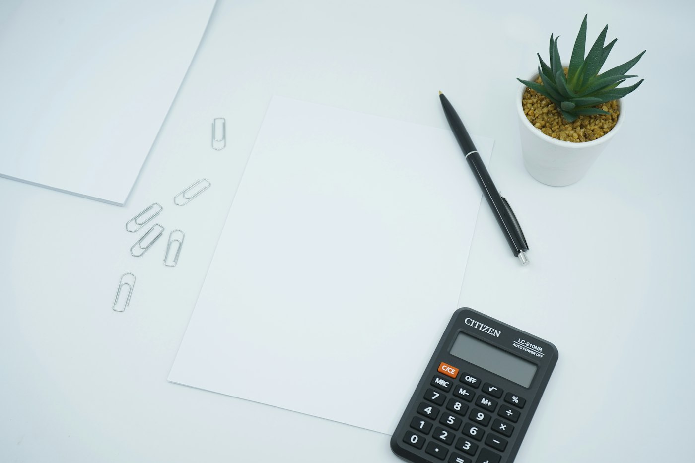 Calculadora e caderno sobre a mesa para cálculo de preços