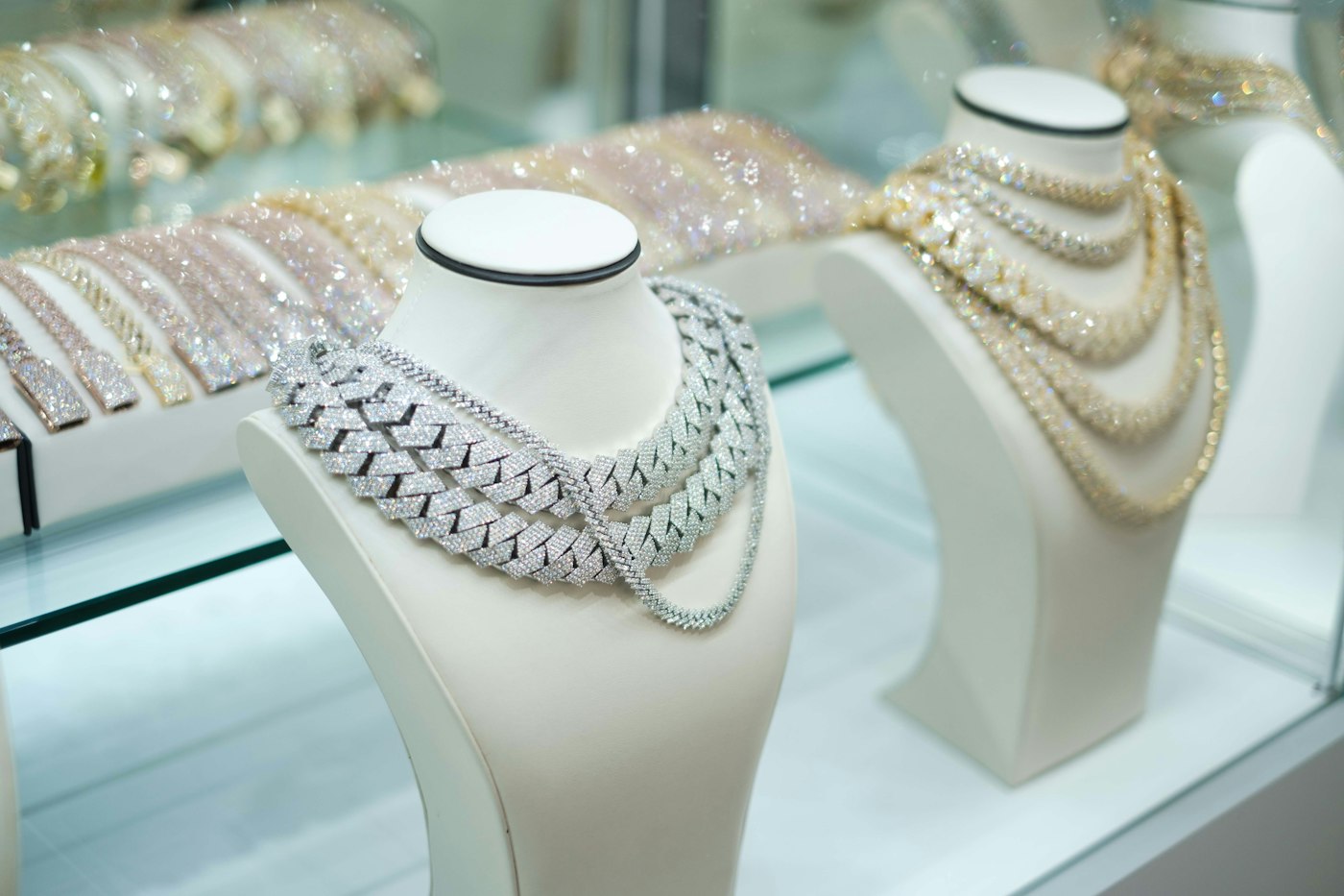 Colares de semijoias expostos em mostruário branco