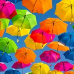 Guarda-chuvas coloridos suspensos contra o céu azul